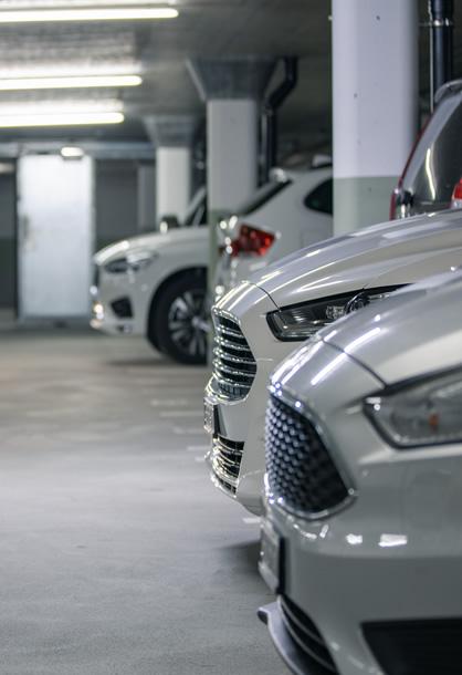 Auto parcheggiate in un garage sotterraneo con illuminazione artificiale.