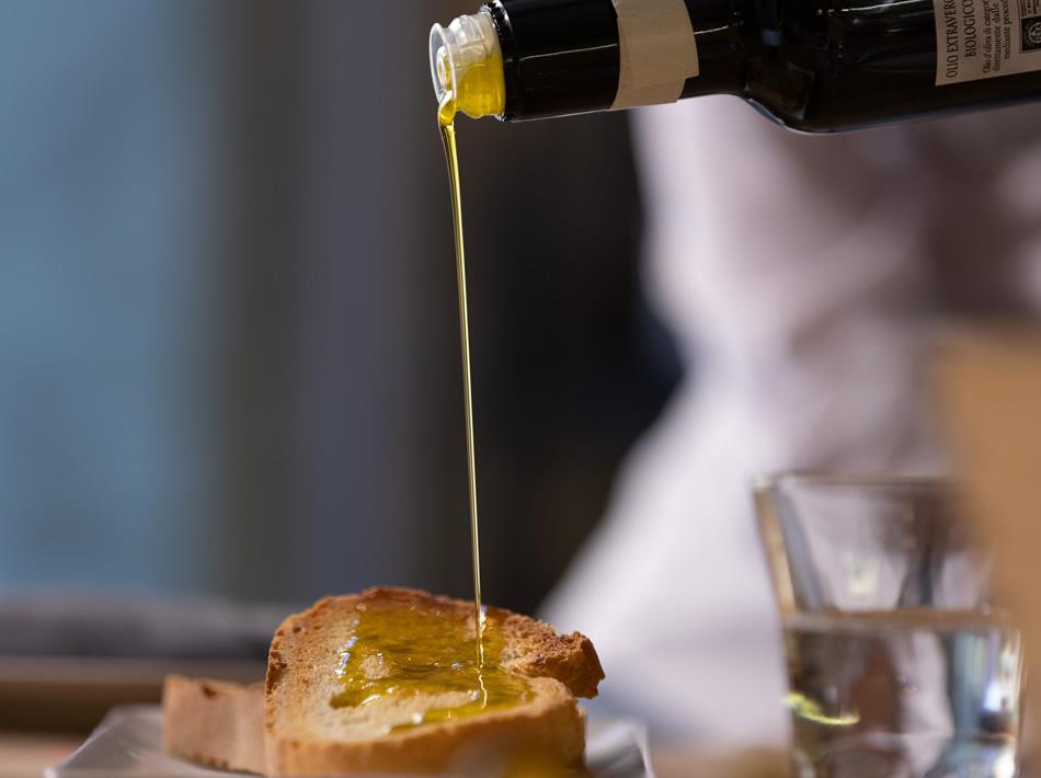Extra virgin olive oil poured on a slice of bread.