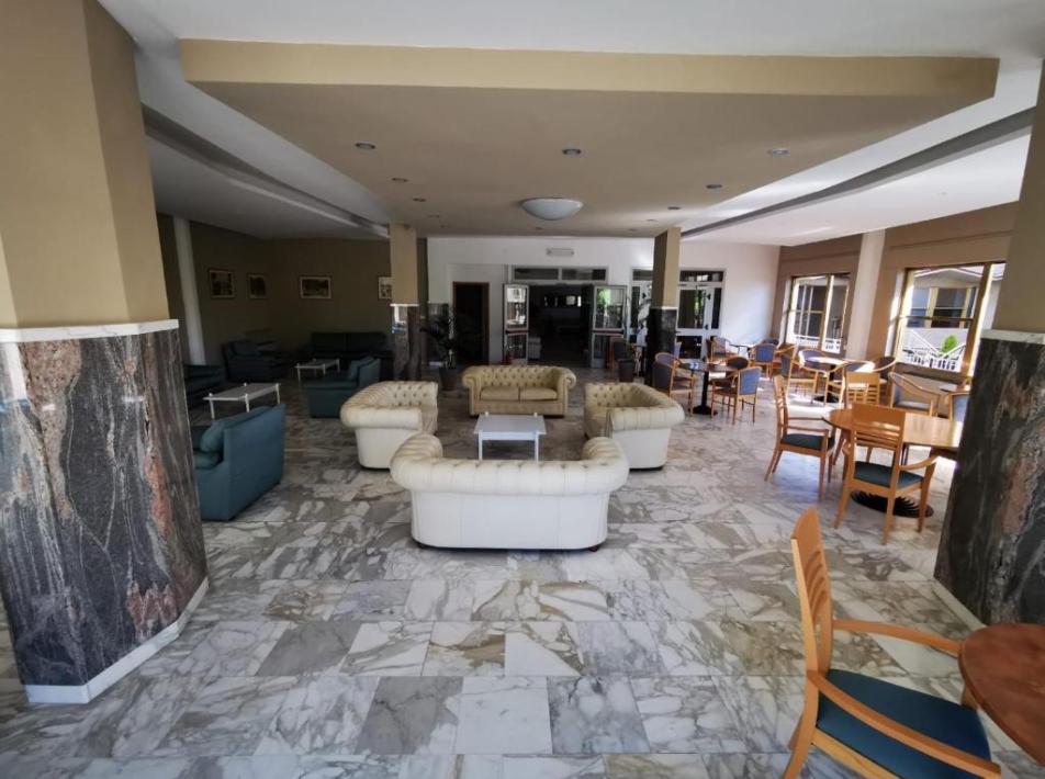 Sala comune elegante con divani bianchi e pavimento in marmo.
