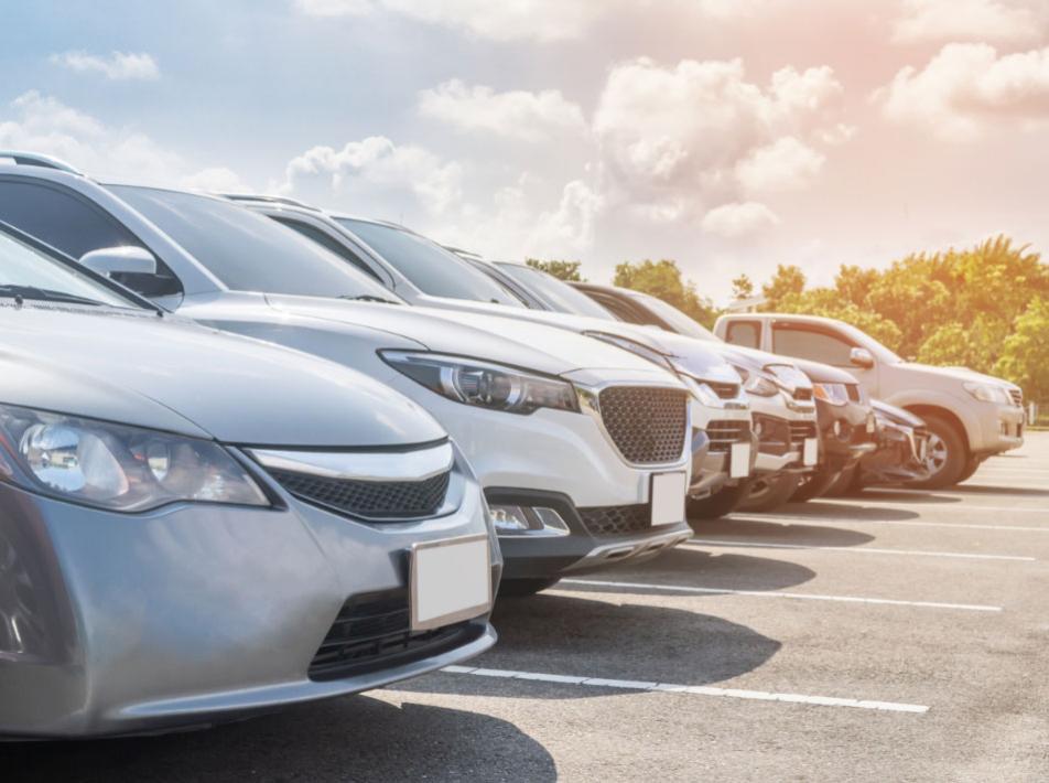 Cars parked in a row in an outdoor parking lot.